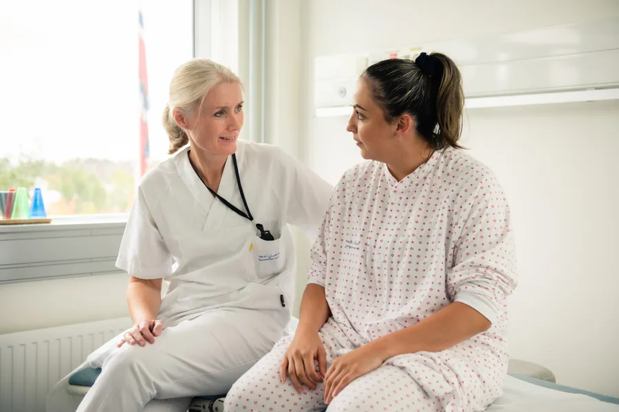 En lege som snakker med en pasient