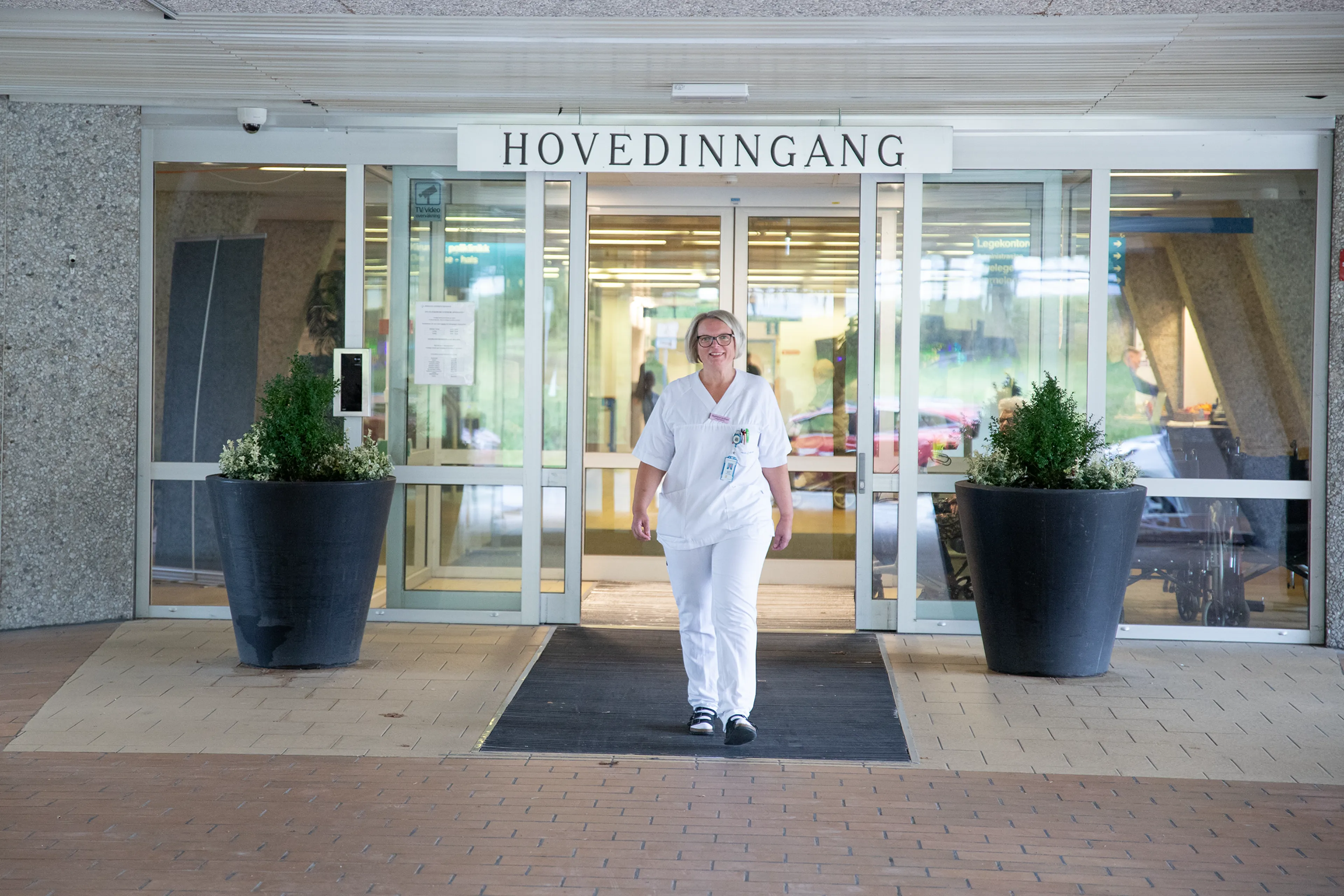 sykepleier foran hovedinngang